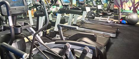 Ett gym med flera löpband, crosstrainers och annan träningsutrustning.