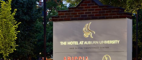 A hotel sign with the name "The Hotel at Auburn University" and "Ariccia" on it.
