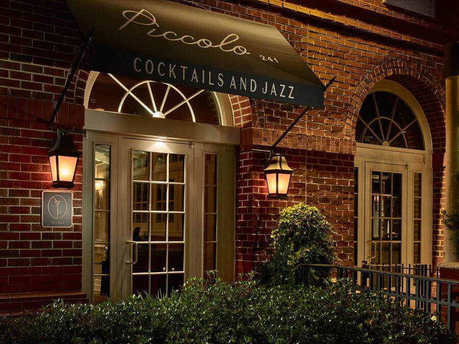 A brick building with a sign reading "Piccolo Cocktails and Jazz".