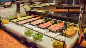 A buffet with various meats, vegetables, and condiments.
