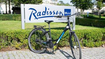 A bicycle parked in front of a sign for Radisson Blu Parkhotel.