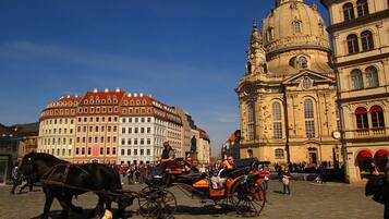 Ein historischer Platz mit einer Kutsche, einer markanten Kirche und klassischer Architektur.