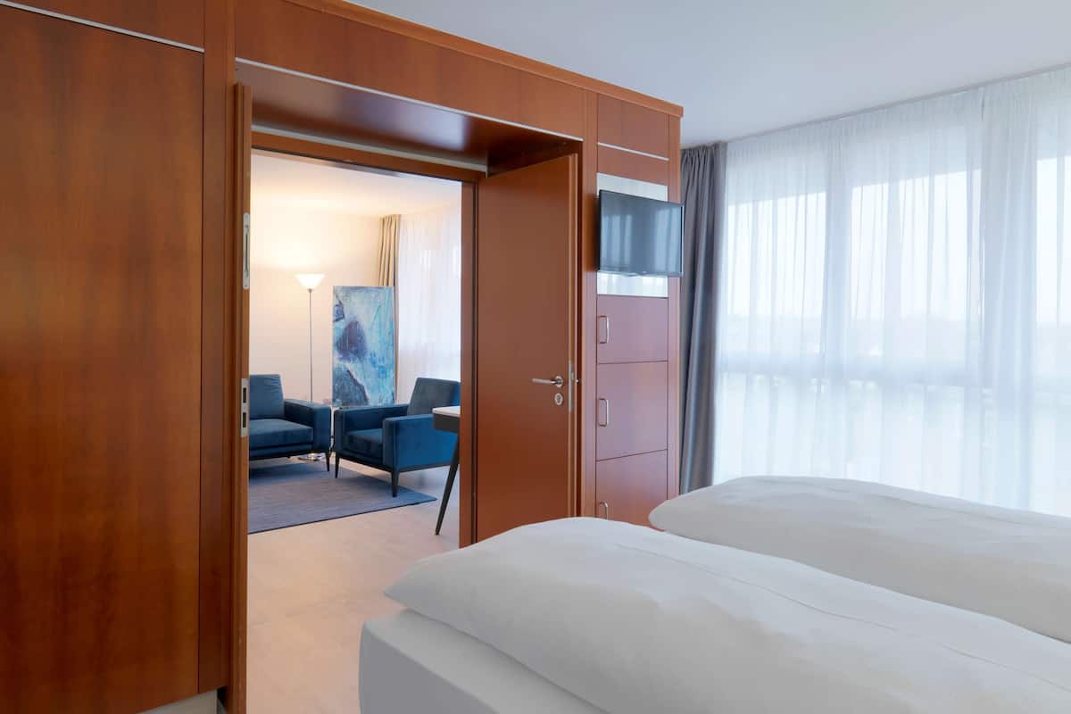 Una habitación de hotel con una cama grande, un armario, un escritorio y una televisión.