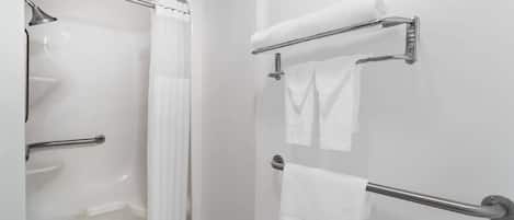 A bathroom with a bathtub, a shower, and a toilet. There are two towel racks with towels hanging on them.