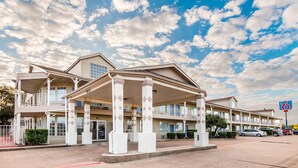 A motel with a covered front porch and multiple balconies.