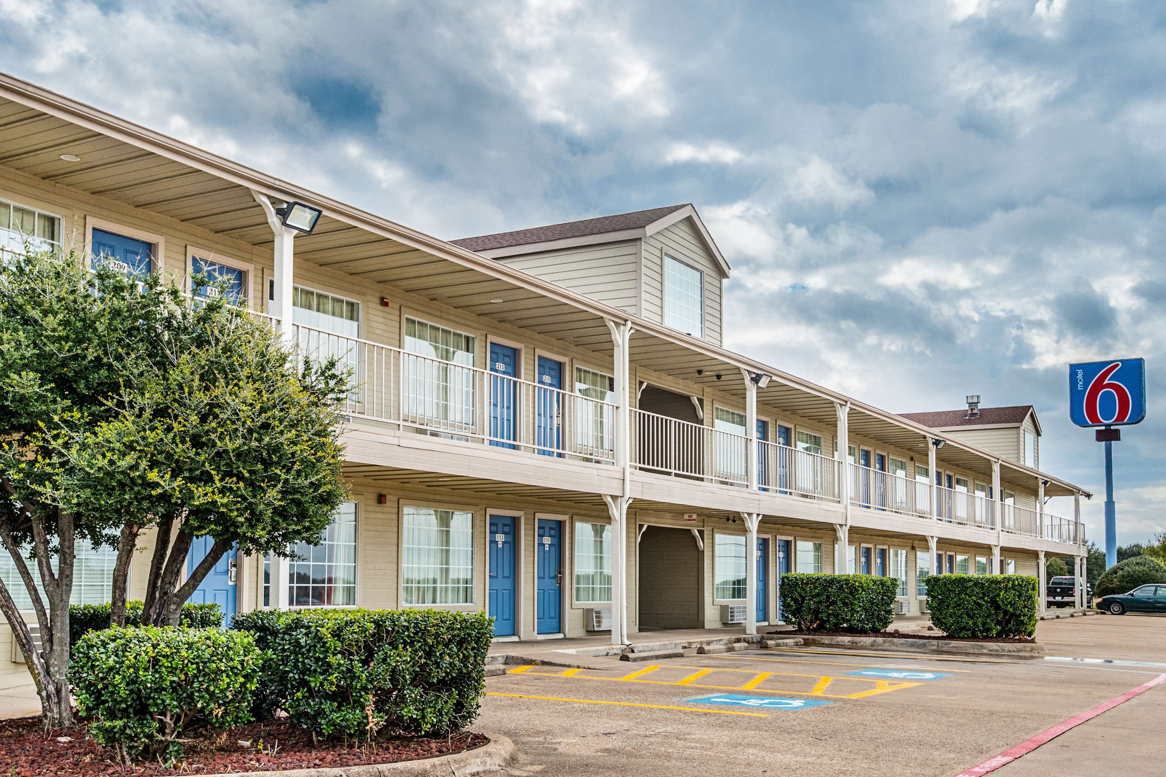 A motel with a two-story structure, multiple rooms, and a parking lot with handicapped accessibility.