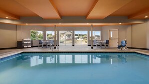 An indoor swimming pool with clear glass walls, a ceiling with wooden beams, and a view of the outside. - La Quinta Inn & Suites by Wyndham Springfield (Springfield)