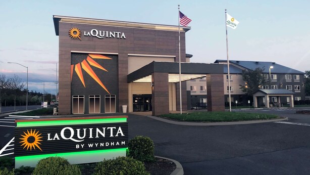 A hotel entrance with a sign reading "LA QUINTA BY WYNDHAM". - La Quinta Inn & Suites by Wyndham Springfield (Springfield)