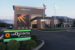 A hotel entrance with a sign reading "LA QUINTA BY WYNDHAM".