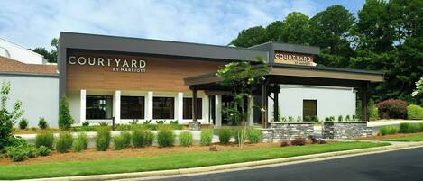 A Courtyard by Marriott hotel with a modern design, featuring a covered patio area and landscaped surroundings.