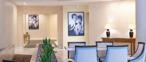 A hotel lobby with a reception desk, seating area, and a staircase.
