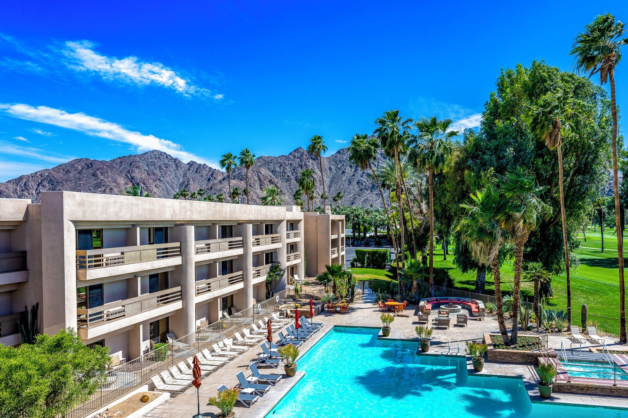 Un hôtel doté d'une piscine, d'un espace extérieur aménagé et offrant une vue sur les montagnes.
