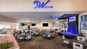 A hotel lobby with a stage, seating area, and a reception desk. - Indian Wells Resort Hotel (Indian Wells)