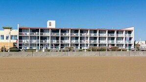 A multi-story hotel with balconies, located near a beach. - Ocean 27 (Virginia Beach)