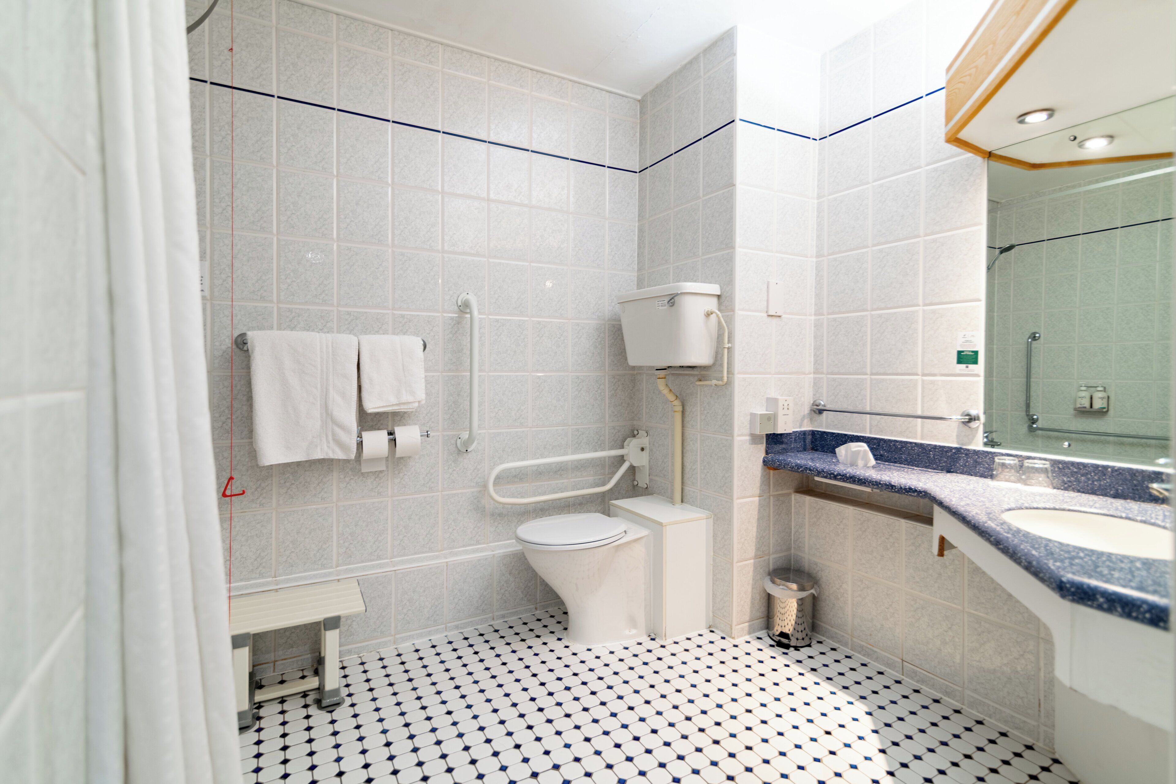 A bathroom with a toilet, bidet, sink, and a mirror.