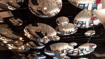 A ceiling with multiple circular mirrors reflecting the interior of a modern building.