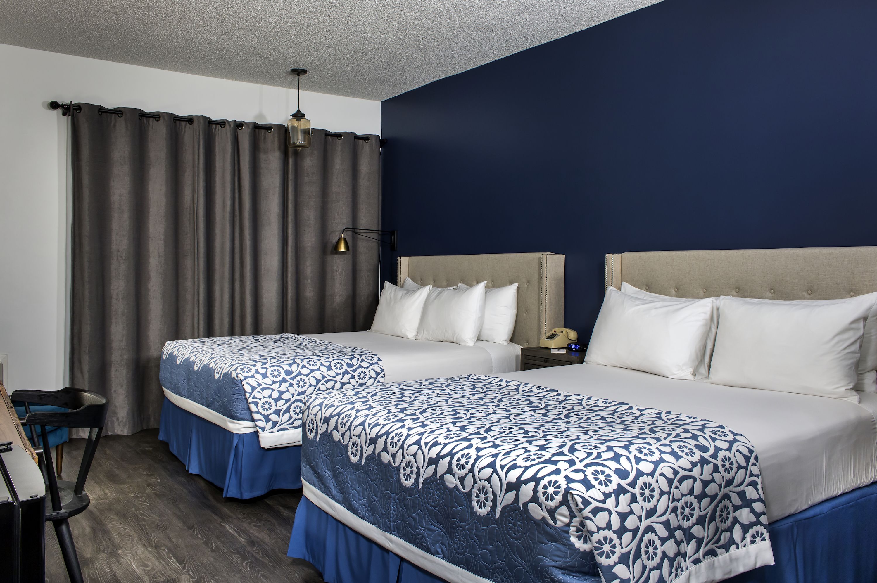 Une chambre d’hôtel avec deux lits, un bureau et une chaise.