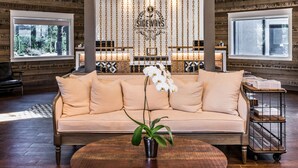 A cozy lounge area with a sofa, a potted orchid, and a wooden coffee table.