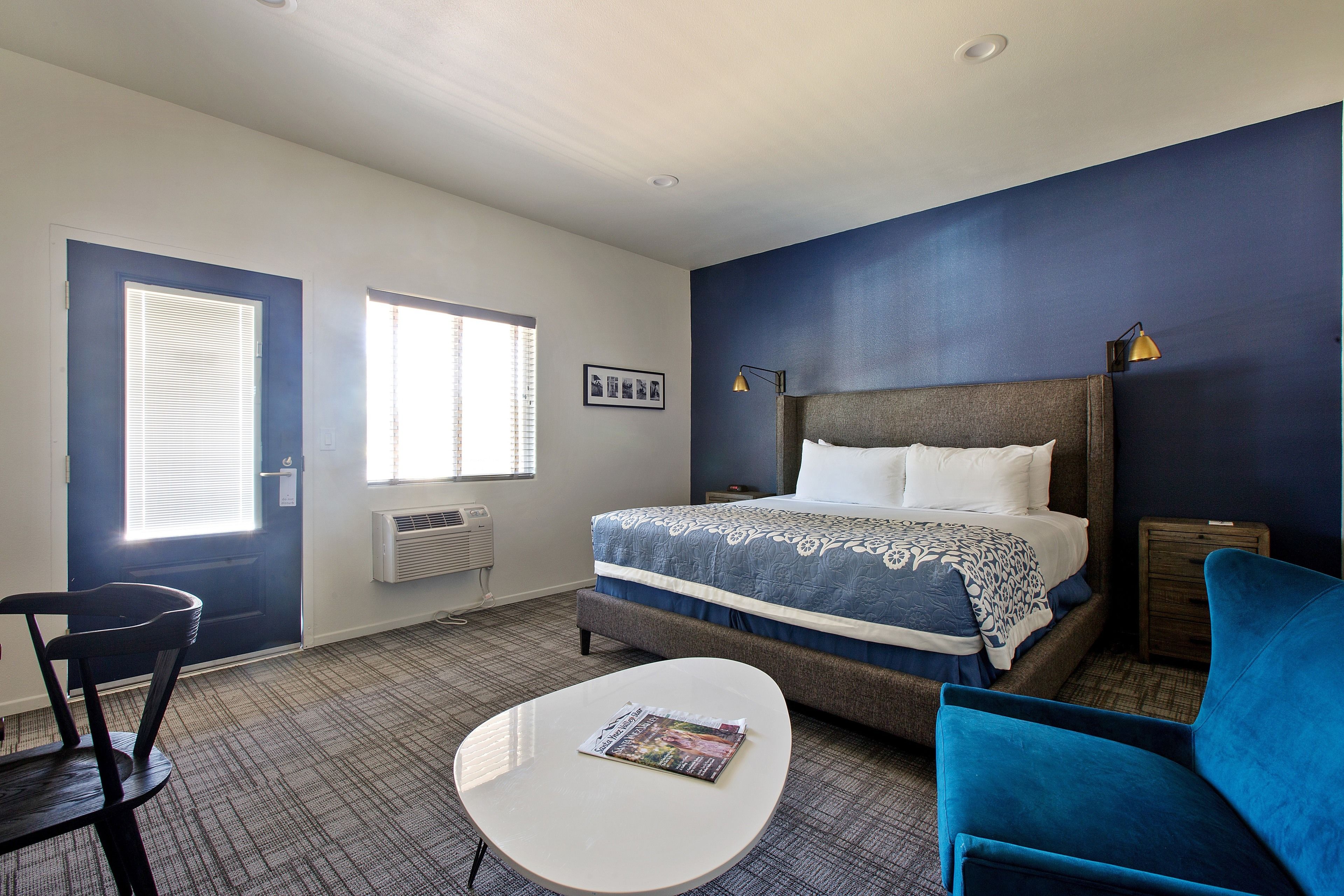 Ein Hotelzimmer mit Bett, Schreibtisch, Stuhl und Fenster.