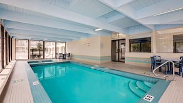 Relax by the pool surrounded by lounge chairs and tables.