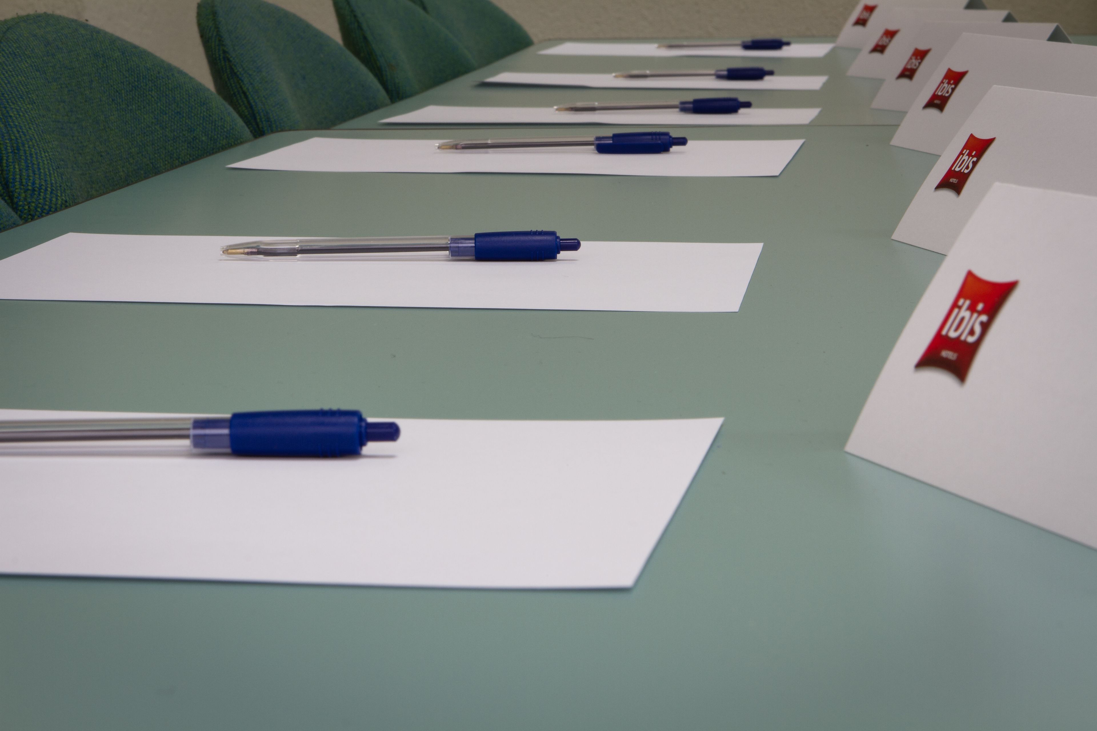 Una mesa de conferencias con documentos y bolígrafos.