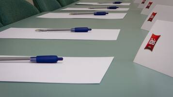 Una mesa de conferencias con documentos y bolígrafos.