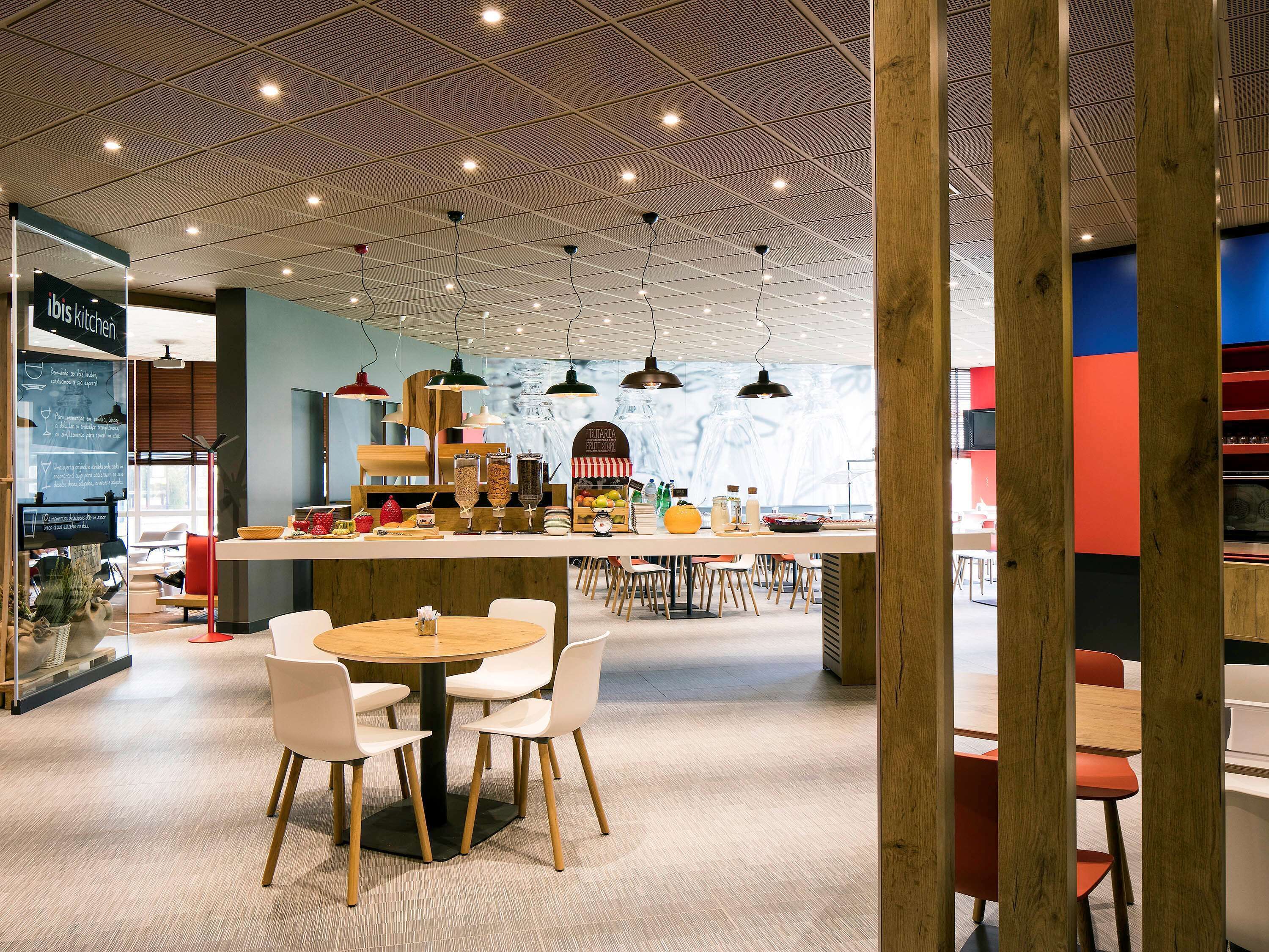 A modern cafe with a central bar area, seating arrangements, and a visible menu board.