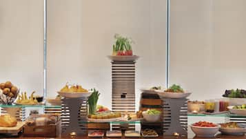 A buffet setup with various food items and a central decorative plant.