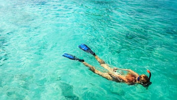 A person snorkeling in clear blue water.