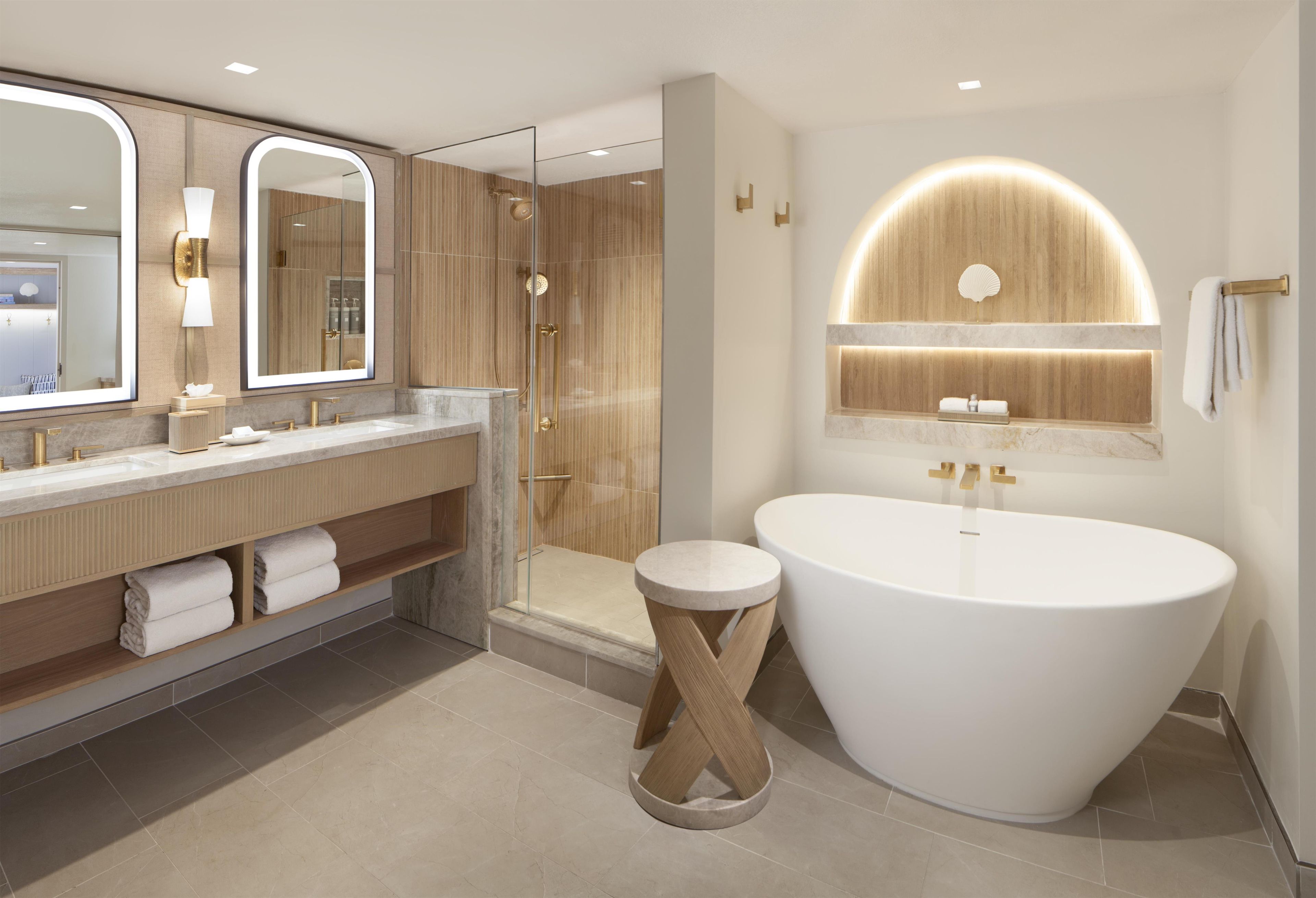 A modern bathroom with a freestanding bathtub, a glass-enclosed shower, and a vanity with a large mirror.