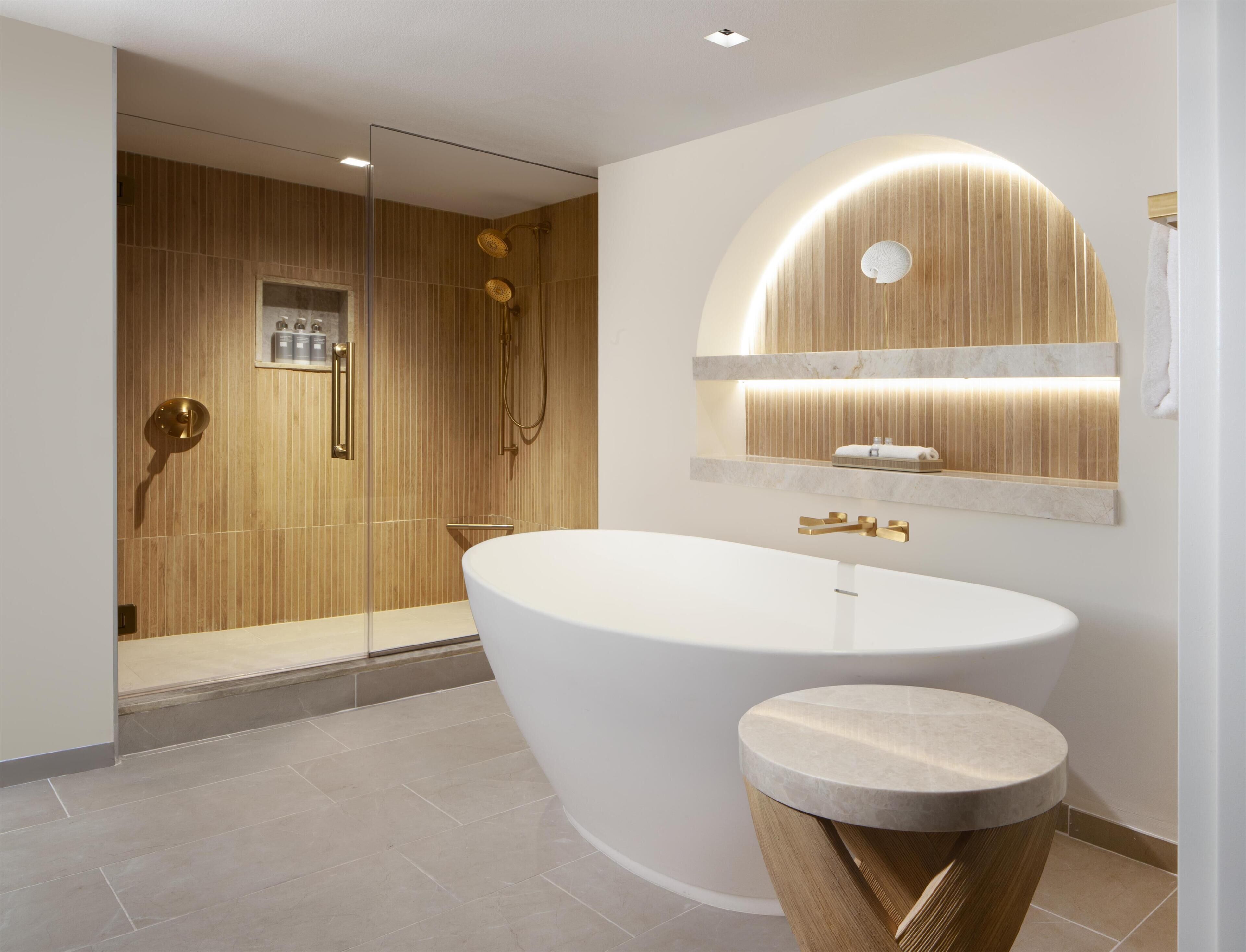 Un baño moderno con una bañera independiente, un tocador con espejo y una zona de ducha.