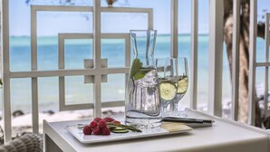 A table with a glass pitcher, a glass with a slice of lime, and a plate with raspberries and a sprig of rosemary. - Baker's Cay Resort Key Largo, Curio Collection by Hilton (Key Largo)