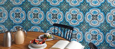 A dining table with plates of food, a coffee cup, and an open book.