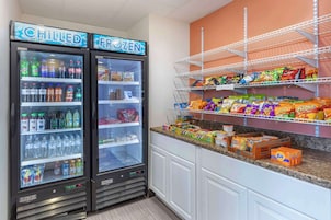 Dos dispensadores de bebidas refrigeradas, con rótulos que indican 'CHILLED' y 'FROZEN', y diversas bebidas en su interior.