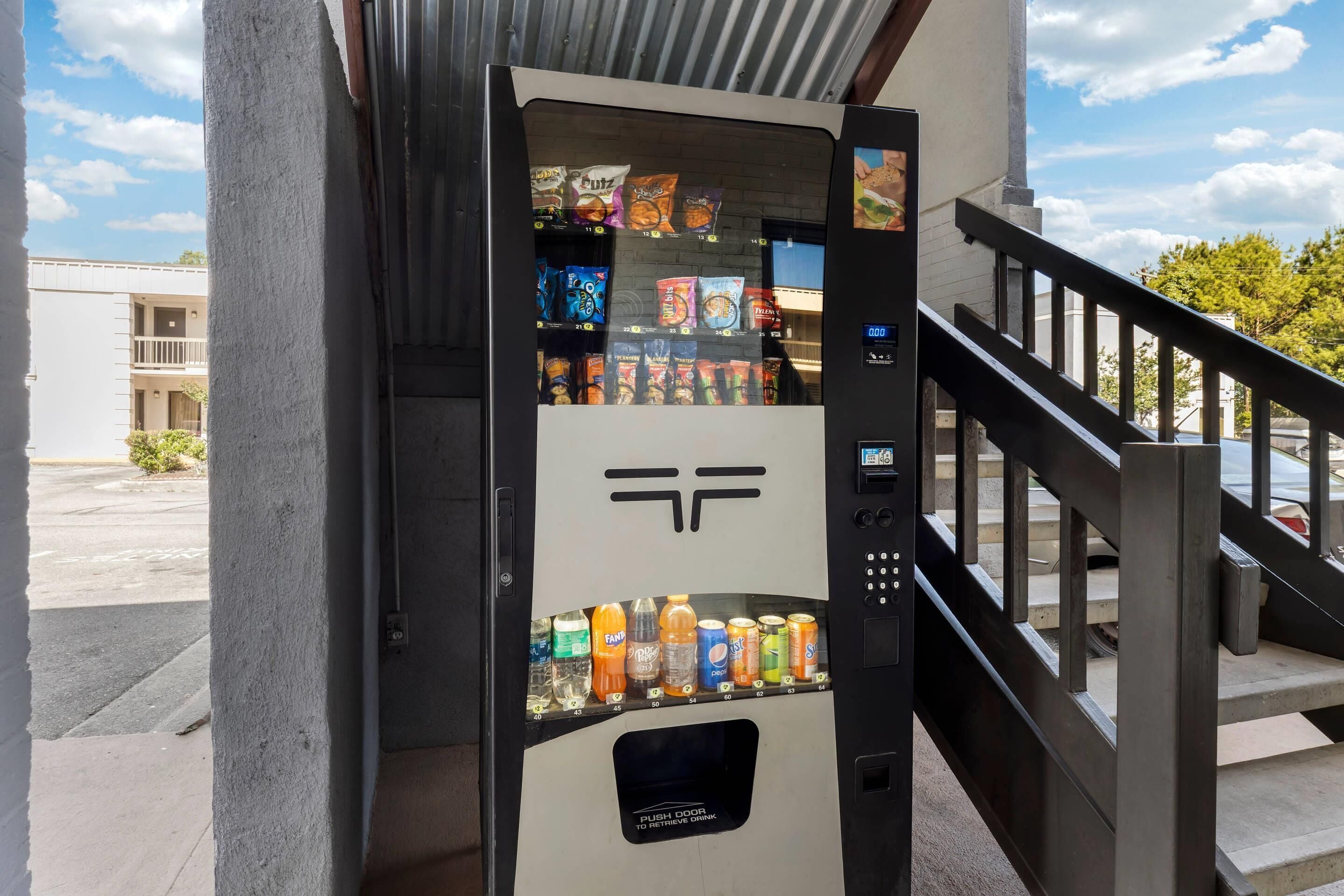 A vending machine with a logo, various snacks, and beverages.