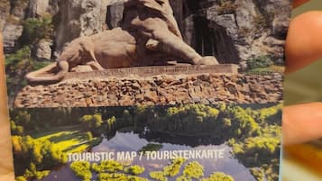 A tourist map with a lion statue and a building in the background.