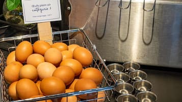 A basket of eggs, a stainless steel sink, and metal bowls.
