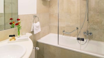 A modern bathroom with a glass-enclosed shower, a white sink, and a toilet.