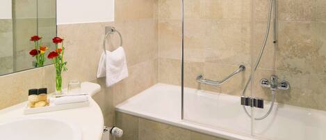 A modern bathroom with a glass-enclosed shower, a white sink, and a toilet.