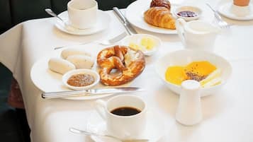 A breakfast table with a variety of food items and utensils.