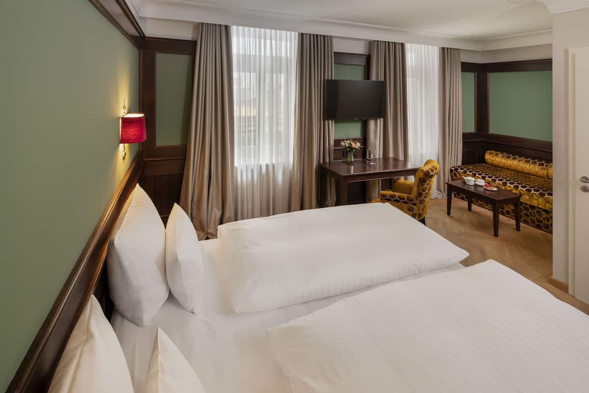 Een hotelkamer met een groot bed, een bureau met een flatscreen televisie, een bank en een stoel.