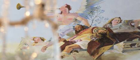 Un mural con figuras y alas, posiblemente representando una escena mitológica.