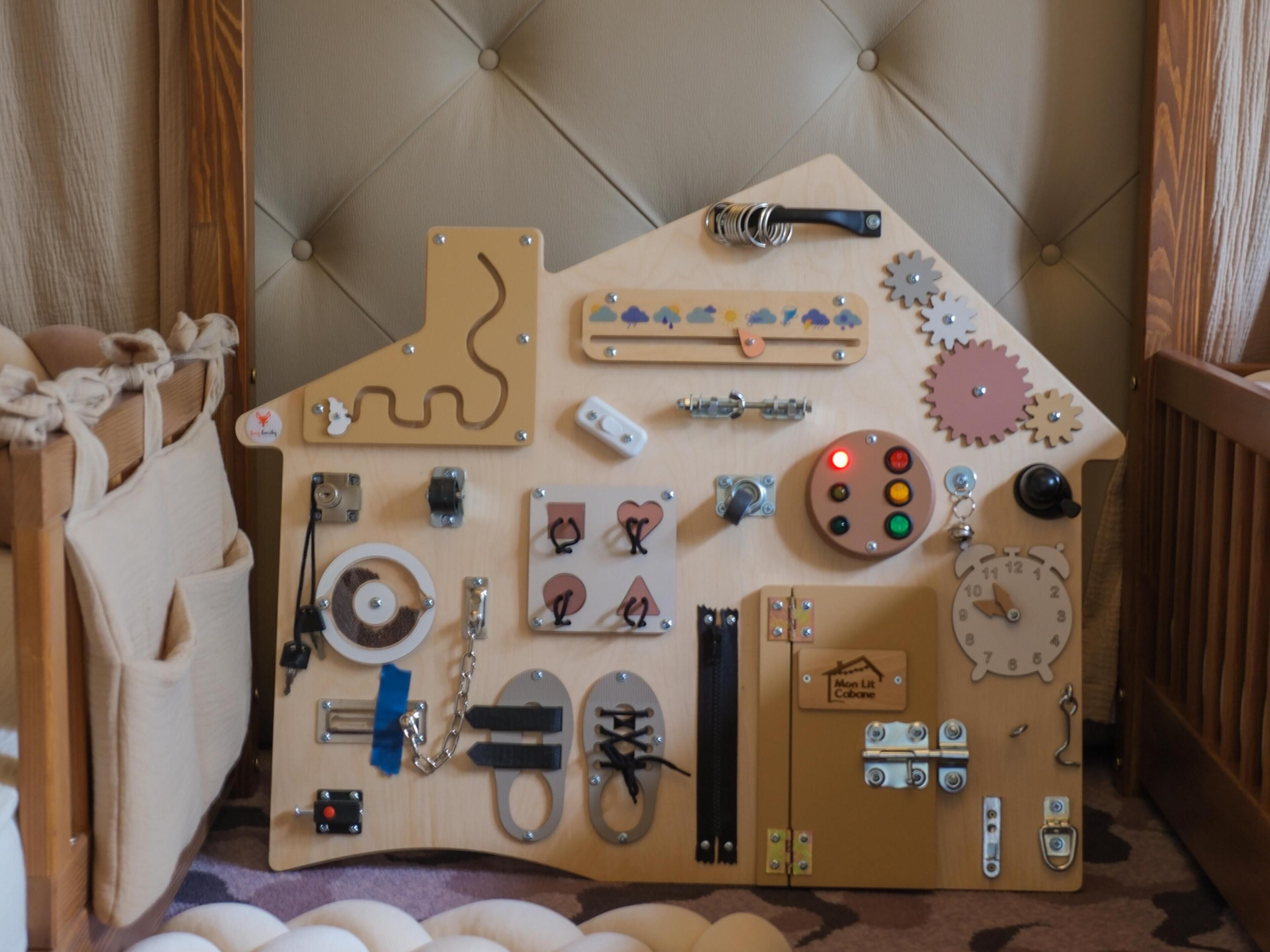 A room with a tufted headboard, a wooden dresser, and various items on the dresser including a clock, a small shelf, and a decorative piece shaped like a house.