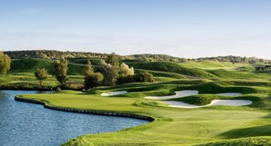 A golf course with water hazards, sand bunkers, and a flagstick.