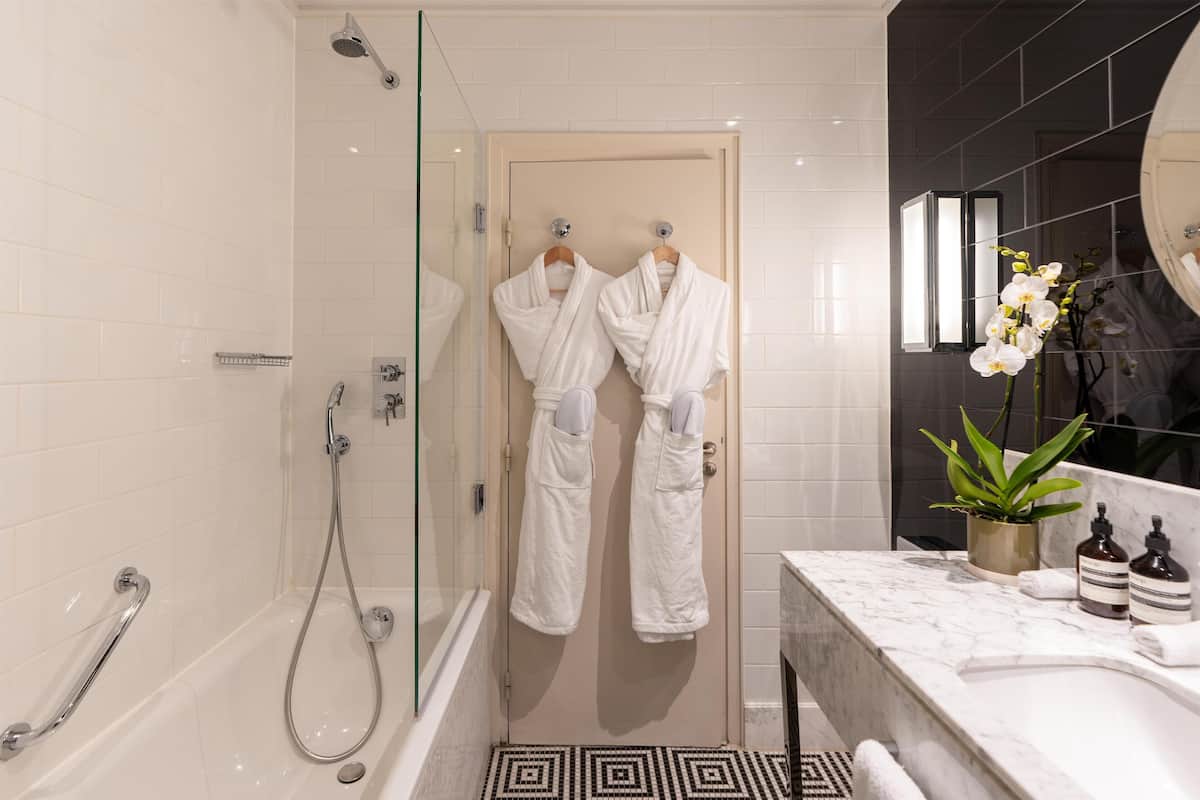 Ein modernes Badezimmer mit einer gläsernen Duschkabine, einer Badewanne und einem мрамор-Waschtisch.