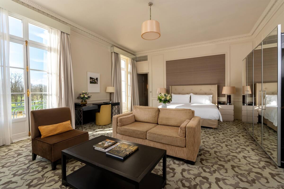 Une chambre d’hôtel avec un grand lit, un canapé, une table basse et un bureau.