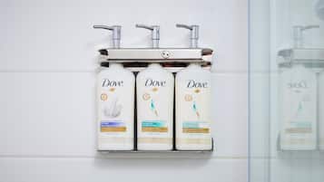 Trois produits de la gamme Dove pour les soins personnels, présentés sur un distributeur mural.
