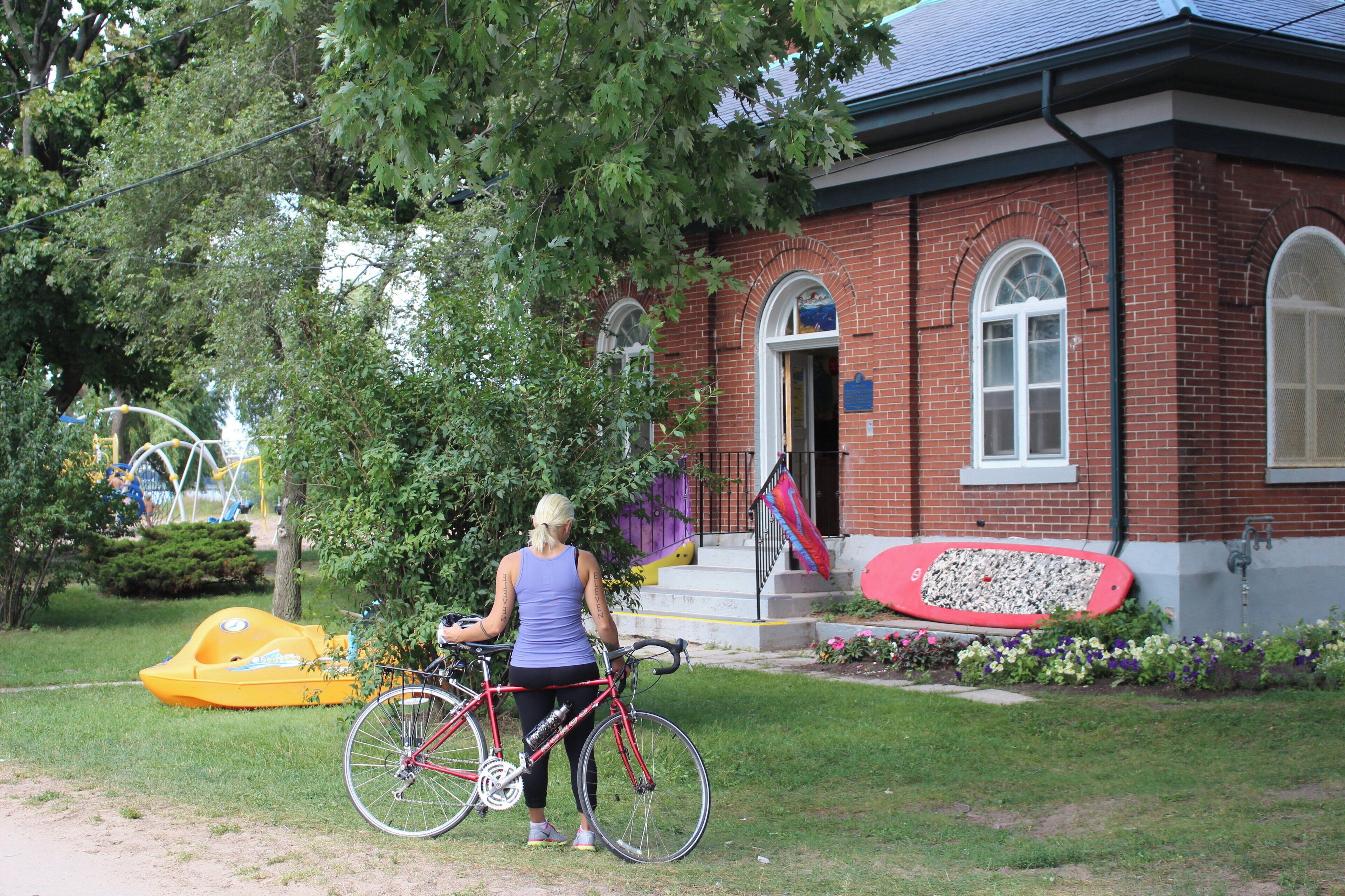 A brick building with a red bicycle parked in front.