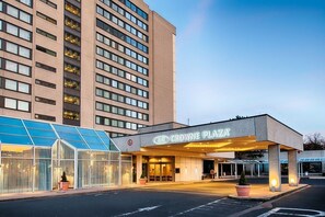 A hotel entrance with a glass facade and a sign reading "Crowne Plaza".