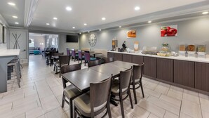 A modern kitchen and dining area with a central island, dining tables, and chairs. - Quality Inn Near Lake Marble Falls (Marble Falls)